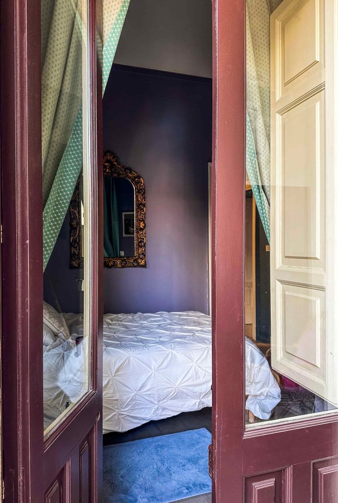 View through doorway into Room Pirandello, antique gilded mirror on the wall 
